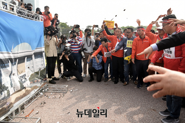 ▲ 소상공인 단체 대표들이 국회를 규탄하며 국회사진에 숟가락을 던지는 퍼포먼스를 벌이고 있다.ⓒ뉴데일리 공준표 기자