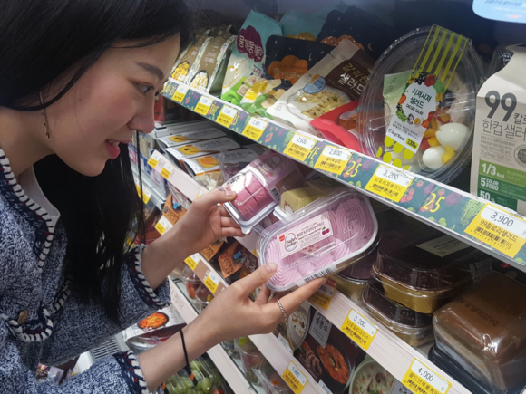 ▲ 한 여성 고객이 GS25에서 고객이 디저트 상품을 고르고 있다. ⓒGS25