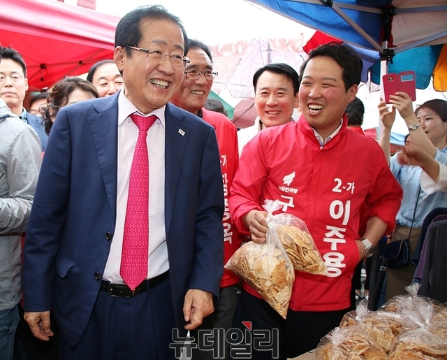 ▲ 홍준표 대표가 누룽지를 구입하며 상인과 활짝 웃고 있다.ⓒ뉴데일리