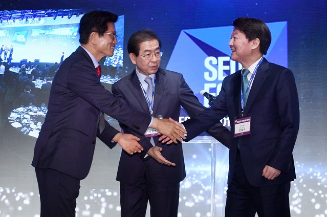 ▲ 자유한국당 김문수 서울시장 후보와 바른미래당 안철수 서울시장 후보가 악수를 나누고 있다. 사진 가운데는 더불어민주당 박원순 서울시장 후보. ⓒ뉴시스 사진DB(서울경제 제공)