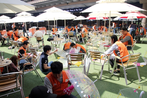 ▲ 호반건설 임직원 봉사단 '호반사랑나눔이'가 어린이 안전우산을 제작하고 있다. ⓒ호반건설