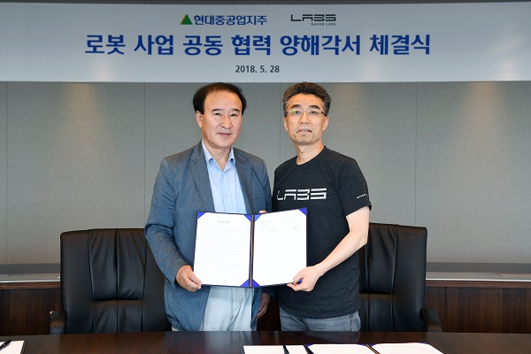 ▲ 윤중근 현대중공업지주 로봇사업부문 대표(왼쪽)와 송창현 네이버랩스 대표가 28일 서울 계동 현대빌딩에서 서비스로봇 진출 관련 업무협약을 맺은 후 기념촬영을 하고 있다. ⓒ현대중공업지주