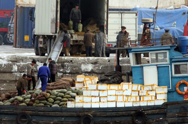▲ 중국에서 구매한 물품들을 북한으로 옮기기 위해 배에 싣는 北무역일꾼들. ⓒ美자유아시아방송 관련보도 화면캡쳐.