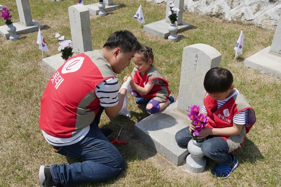 ▲ 롯데건설 직원 가족들이 묘역 단장을 하고 있다. ⓒ롯데건설