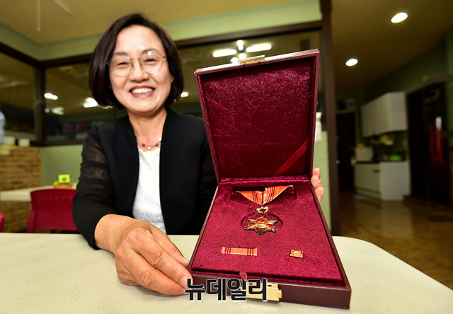 ▲ 전 교사는 지난달 23일 교육부와 한국교직원공제회(이사장 문용린)이 주관한 '제7회 대한민국 스승상'에서 대상을 수상했다. 그에게는 홍조근정훈장과 상패, 상금 2천만원이 부상으로 주어졌다. 기자의 요청에 전 교사가 쑥스러워하며 훈장을 보여줬다. ⓒ 뉴데일리 정상윤 기자