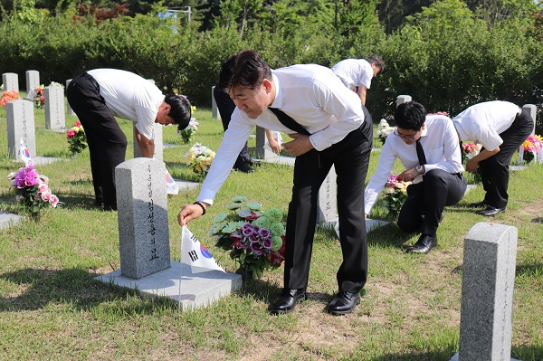 ▲ 맥키스컴퍼니 임직원들이 1일 대전현충원에서 묘역에 태극기 꽂기 봉사를 하고 있다. ⓒ맥키스컴퍼니