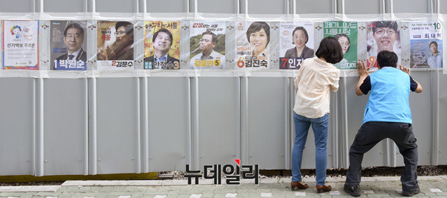 ▲ 6.13 지방선거 공식 선거운동이 시작된 지난달 31일 선관위 관계자들이 각 후보들의 벽보를 붙이고 있다. ⓒ뉴데일리 이종현 기자