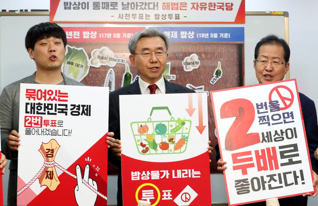 ▲ 자유한국당 홍준표 대표를 비롯한 중앙선대위 위원들이 7일 서울 여의도 당사에서 '사전투표는 밥상투표'라며 1년전 밥상과 현재밥상을 비교하는 차림표 앞에서 구호를 외치고 있다. ⓒ뉴시스 사진 DB