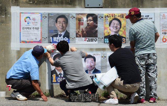 서울시 어느 한 지역에서 6·13 지방선거 벽보를 붙이고 있는 모습. ⓒ뉴데일리 공준표 기자