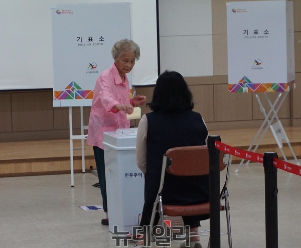 ▲ 제7회지방동시선거일인 13일 충북 청주시 상당구 용암제1투표장에서 한 할머니가 투표한 용지를 투표함에 넣고 있다.ⓒ김정원 기자