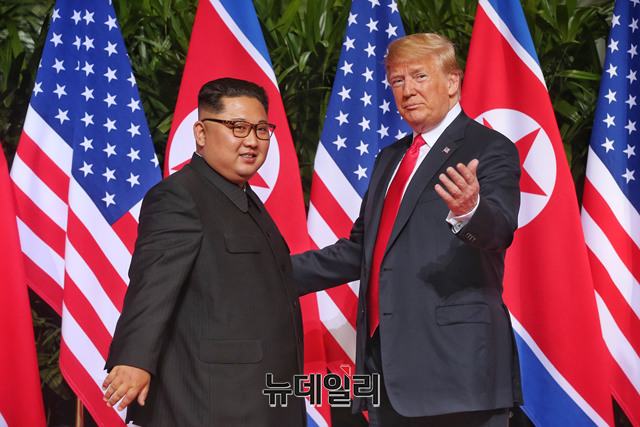 ▲ 도널드 트럼프 미국 대통령(오른쪽)과 김정은 북한 국무위원장이 12일(현지시간) 싱가포르 카펠라 호텔에서 정상회담을 하기 전 인사를 나누고 있다. (사진=싱가포르 통신정보부)