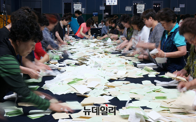 ▲ 제7회 전국동시지방선거 및 국회의원 재·보궐선거가 실시된 13일 서울 영등포 다목적배드민턴체육관에 마련된 개표소에서 사무원들이 투표용지를 분류하고 있다. ⓒ뉴데일리 이기륭 기자