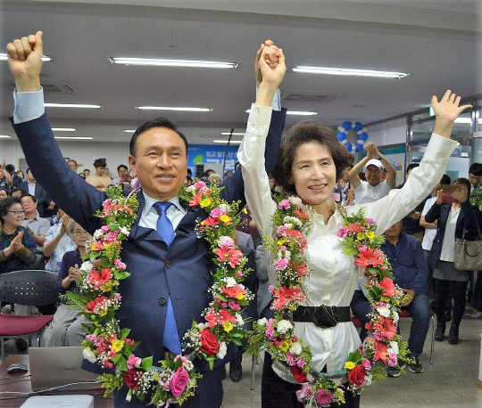 ▲ 재선에 도전한 더불어민주당 구본영 천안시장 후보(65)가 당선이 확정되자 14일 오전 불당동 선거사무실에서 부인과 함께 꽃다발을 목에 걸고 만세를 하며 환호하고 있다.ⓒ구본영 선거사무실