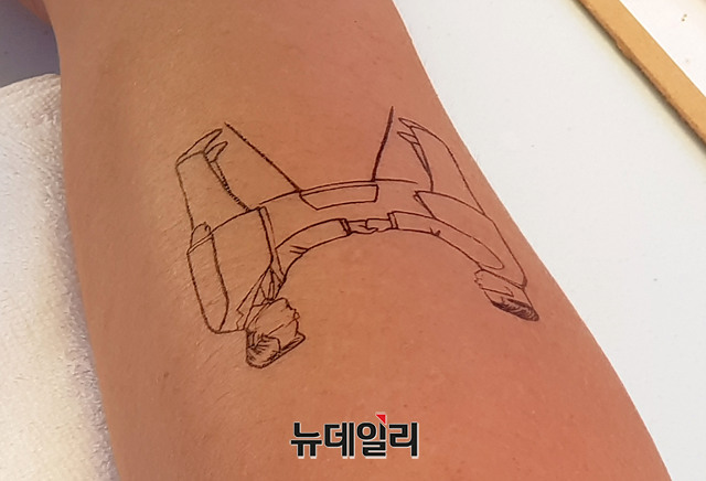 ▲ '6·15 공동선언실천 남측위원회'가 6·15 남북공동선언 18주년을 맞이해 15일 오전 서울시청광장에서 '여기는 판문점입니다'를 주제로 평화통일박람회를 개최했다. 한 시민이 남북정상 캐리커쳐 헤나를 체험하고 있다. ⓒ뉴데일리 정상윤