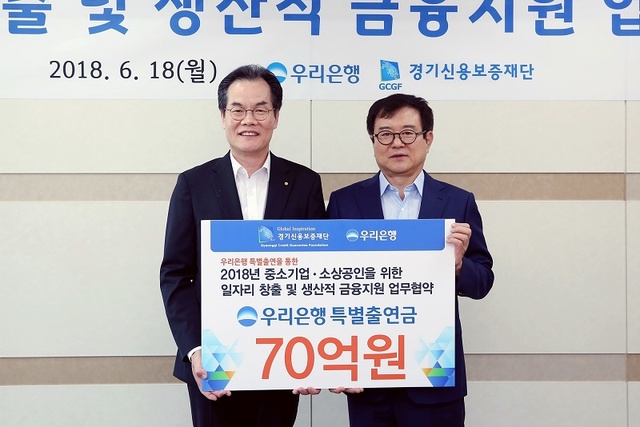 ▲ 이동연 우리은행 부행장(왼쪽)이 김병기 경기신용보증재단 이사장과 지난 18일 경기도 수원시 소재 경기신용보증재단에서 업무협약을 체결한 뒤 기념촬영을 하고 있다. ⓒ 우리은행