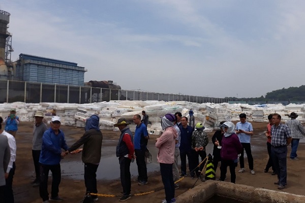 ▲ 대진침대의 라돈이 검출된 매트리스를 충남 당진항 야적장에 쌓아 놓은 곳에서 지난 20일 인근 주민과 당국 관계자들이 매트리스 해체와 관련한 문제를 놓고 협의하고 있다.ⓒ당진시