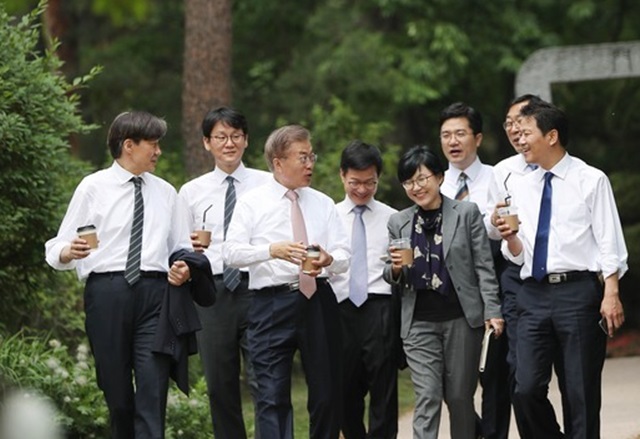 ▲ 문재인 대통령과 청와대 참모진이 테이크아웃커피를 마시면서 산책하는 모습. ⓒ청와대 제공