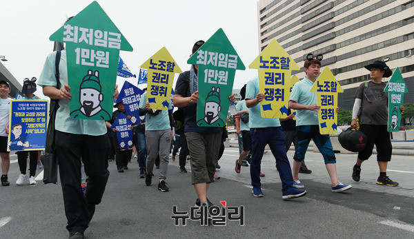 ▲ 민노총 조합원들이 최저임금 1만원을 요구하는 피켓을 들고 있는 모습. ⓒ뉴데일리 DB