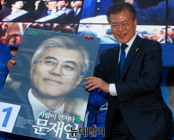 ▲ 문재인 대통령이 지난해 4월 17일 ‘2012년 대선벽보’를 내리는 모습. ⓒ뉴데일리 DB