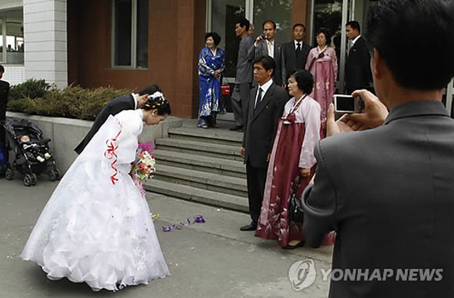 평양의 한 결혼식장에서 신랑과 신부가 부모에게 절하는 모습. 이런 결혼식이 가능한 북한 최상위 계층에 대한 주민들의 불만이 강력범죄로 이어지고 있다고 한다. ⓒ연합뉴스. 무단전재 및 재배포 금지.