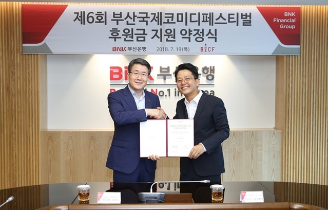 ▲ 성동화 BNK부산은행 경영관리그룹장(왼쪽)과 부산국제코미디페스티벌 김준호 집행위원장이 지난 19일 본점에서 후원금 약정식을 가진 후 기념촬영을 하고 있다. ⓒBNK부산은행