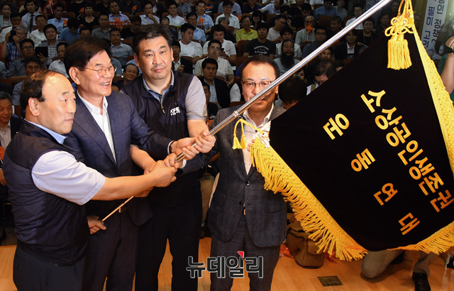 ▲ '소상공인 생존권 운동연대' 공동대표들이 출범식에서 깃발을 흔들고 있다 ⓒ 뉴데일리 공준표