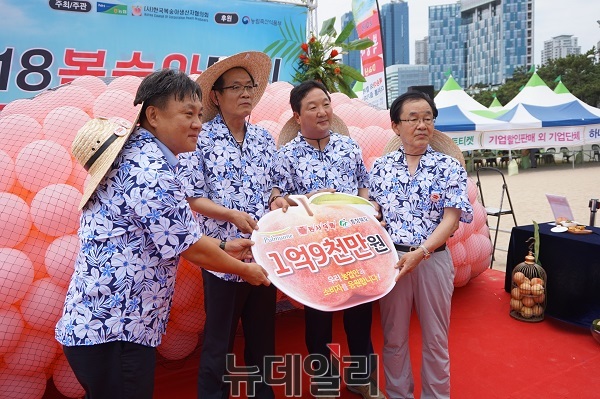 ▲ 김병국 전국 복숭아생산자협의회장(오른쪽)이 28일 부산 해운대해수욕장에서 열린 ‘2018복숭아소비촉진홍보‧복숭아데이’ 에서 1억 9000만원의 복상아상생기금을 전달받고 있다. ⓒ김정원기자