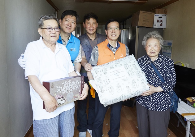 ▲ ㈜한화 경영지원총괄 이성규 전무(사진 왼쪽에서 네 번째, 주황색 조끼)와 서울지방보훈청 오진영 청장  (사진 왼쪽에서 두 번째, 파란색 조끼)은 국가유공자 장옥현님 댁을 방문해 직접 도배 등을 마치고 쿨매트, 건강식품 등 위문품도 전달했다.ⓒ㈜한화