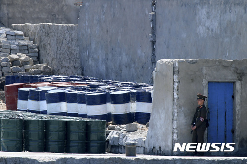 ▲ 2016년 5월8일, 중국 단둥과 인접한 신의주에서 정제 석유 제품을 경비 중인 북한 군인의 모습. ⓒ 사진 뉴시스