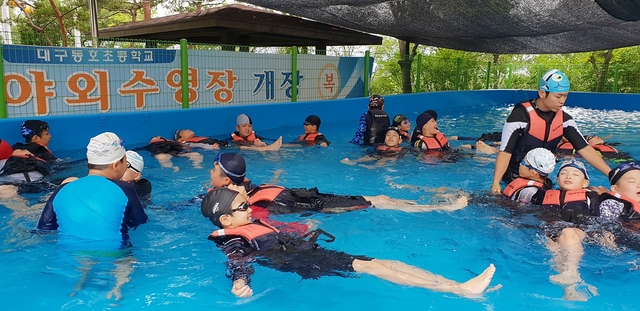 ▲ 동호초에 마련된 조립식 야외 수영장에서 학생들이 생존 수영교육을 받고 있는 모습.ⓒ대구시교육청