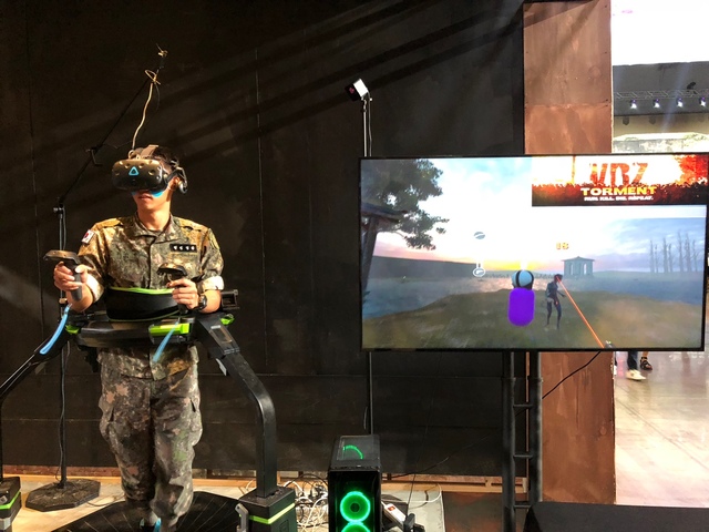 ▲ 행사장을 방문한 관람객이 360도 트레드밀을 활용한 'VR 슈팅게임'을 체험하는 모습. ⓒ연찬모 기자