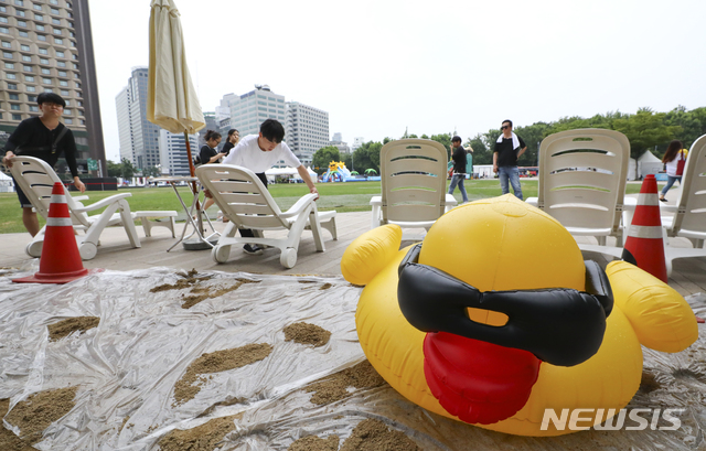 ▲ 2018 서울시 문화로 바캉스 축제를 하루 앞둔 9일 중구 서울시청 앞 광장에서 관계자들이 인공해변을 만들고 있다. ⓒ 뉴시스