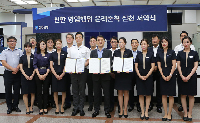 ▲ 16일 서울 중구 신한은행 본점 영업부에서 진행된 ‘신한 영업행위 윤리준칙 실천 서약식’에서 신한은행 위성호 은행장(가운데)과 임직원들이 서약식을 마치고 기념촬영을 하고 있다.ⓒ신한은행