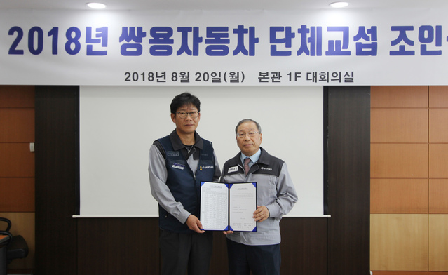 ▲ 쌍용자동차 최종식 대표이사(사진 오른쪽)와 홍봉석 노동조합위원장이 임단협 합의안에 서명 후 기념촬영을 하고 있다.ⓒ쌍용자동차