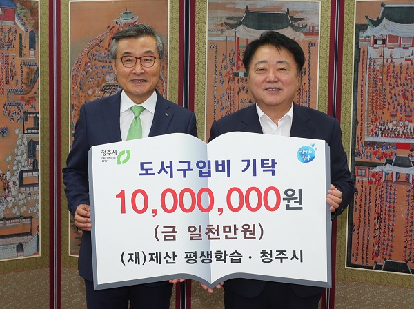 ▲ 김상문 IK그룹 회장(왼쪽)이 21일 오전 시청에서 한범덕 시장에게 도서구입비 1000만원을 전달하고 있다.ⓒ청주시
