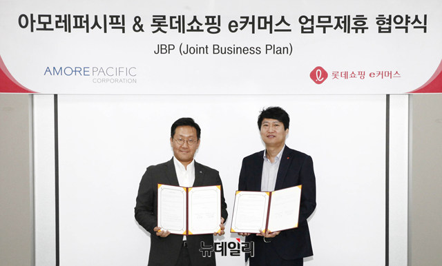 ▲ 롯데쇼핑 e커머스 영업본부 전문사업부문장 김장규 상무(우)가 아모레퍼시픽 디지털Division 사업부장 이민규 상무(좌)와 업무제휴 협약(JBP)을 체결한 후 기념사진을 찍고 있다. ⓒ롯데쇼핑