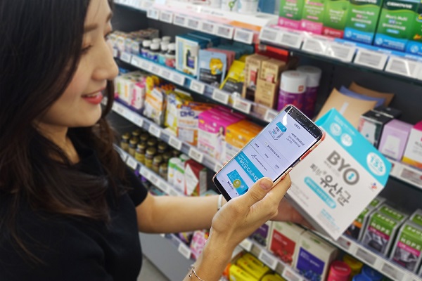 ▲ 올리브영 매장에서 고객이 바코드 스캔 서비스를 이용해 나타난 상품 정보를 모바일로 확인하고 있는 모습ⓒCJ올리브네트웍스