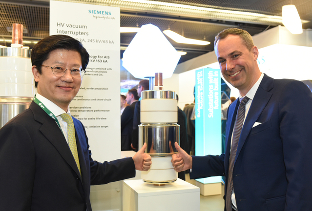 ▲ 허정석 일진전기 부회장(왼쪽)과 세드릭 나이케 지멘스 부회장(오른쪽)이 프랑스 파리에서 열린 2018 국제 대전력망 기술협의회에서 친환경 가스절연개폐장치의 핵심부품을 선보이고 있다ⓒ일진그룹