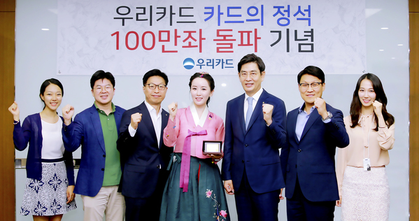 ▲ 지난 30일 우리카드 본사에서 진행된 '카드의정석' 100만좌 돌파 기념식에서 정원재 우리카드 사장(왼쪽에서 다섯번 째)이 김현정 한국화가(왼쪽에서 네번째)에게 감사의 표시로 기념카드를 전달하고, 상품개발에 참여한 유공직원 5명과 함께 기념 촬영을 하고 있다.ⓒ우리카드