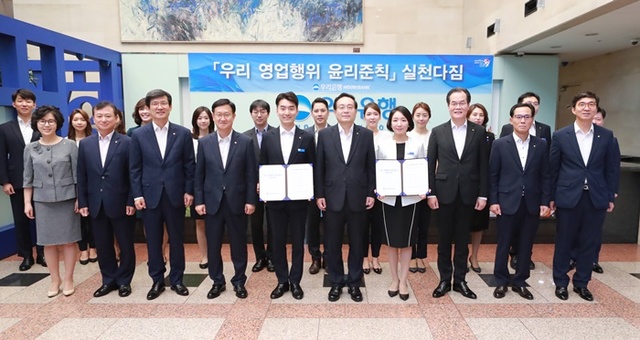 ▲ 손태승 우리은행장(앞줄 왼쪽 여섯번째)은 31일 서울시 중구 본점에서 주요 임원, 직원 대표들과 함께 금융소비자권익 보호를 위한 영업행위 윤리준칙실천 다짐 행사를 실시했다. ⓒ우리은행