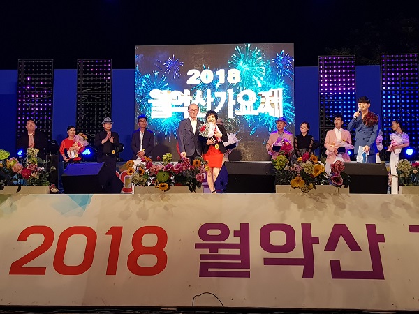 ▲ 2018제천 월악산 가요제에서 대상을 받은 정정숙씨가 금한주 제천부시장과 기념촬영을 하고 있다.ⓒ제천시