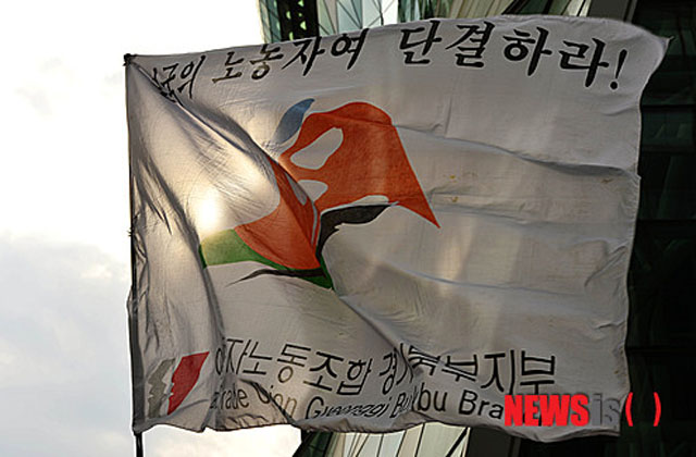 ▲ 2013년 4월 28일 국가인권위 앞에서 노동절 행사를 가진 외국인 근로자 노조가 내건 깃발. 공산당 선언에 나온 