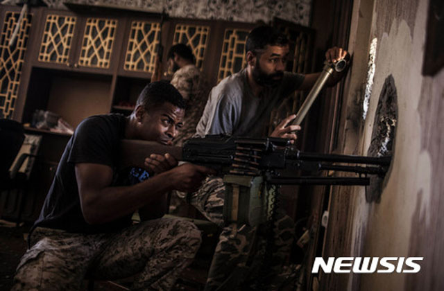 ▲ 2017년 9월 수도 트리폴리에서 반정부 무장세력과 교전하는 친정부 민간 수색대원. ⓒ뉴시스 AP. 무단전재 및 재배포 금지.