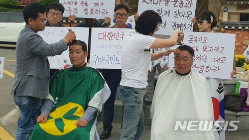 ▲ 지난 6월 10일 경북애국시민연합 회원들이 '새마을 폐지' 공약을 내세운 더불어민주당 장세용 구미시장 후보를 규탄하기 위해 구미시 상모동에 위치한 박정희 대통령 생가에서 삭발식을 진행하는 모습.ⓒ뉴시스