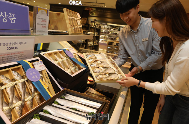 ▲ 고객이 갈치·부세 등 가성비 좋은 수산 선물세트를 고르는 모습. ⓒ롯데백화점