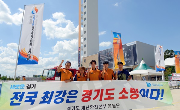 ▲ 2018 충주세계소방관경기대회에서 최강소방관에 오른 홈범석 선수(가운데)가 동료들과 경기도소방본부를 홍보하고 있다.ⓒ충북도