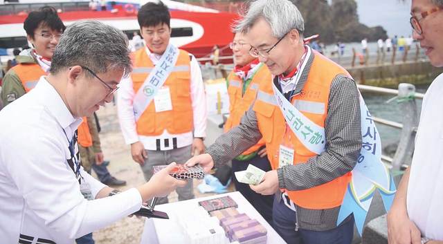 ▲ 대구사이버대 김영걸 기획조정실장이 독도에서 기념품을 구매하며 과세권을 행사하고 있다.ⓒ대구사이버대