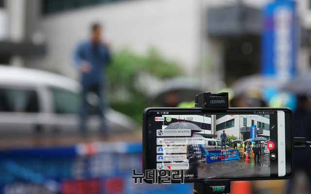 ▲ '자유 유튜브 연대'는 20일 서울 여의도 더불어민주당사 앞에서 '민주당 유튜브 탄압 규탄 집회'를 열었다. 한 유튜버가 시위 현장을 생중계하고 있다. ⓒ뉴데일리 이기륭