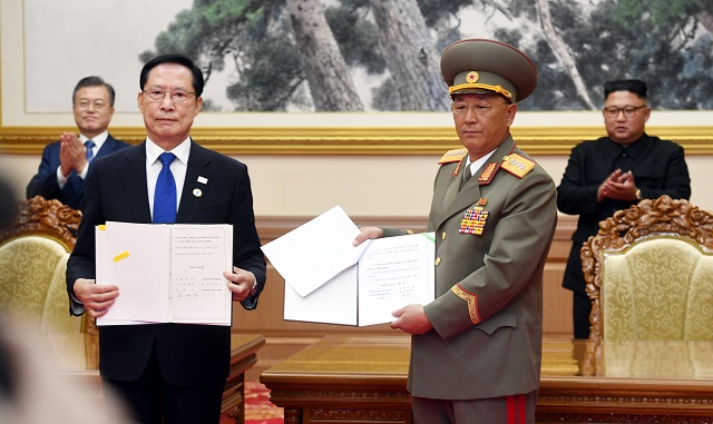 ▲ 19일 오전 평양 백화원 영빈관에서 문재인 대통령과 김정은이 참석한 가운데 송영무 국방부 장관과 노광철 인민무력상이 '판문점선언 이행을 위한 군사분야 합의문'에 서명한 후 취재진을 향해 들어보이고 있다. ⓒ평양사진공동취재단