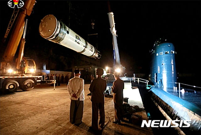 김정은이 지켜보는 가운데 잠수함 발사 탄도미사일(SLBM) 북극성을 잠수함에 탑재하는 모습. ⓒ뉴시스. 무단전재 및 재배포 금지.